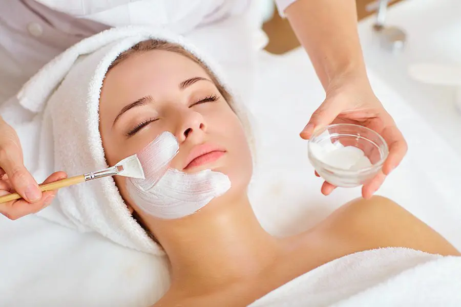 iStock-921797424-900x600-1 Woman receiving facial beauty treatment.